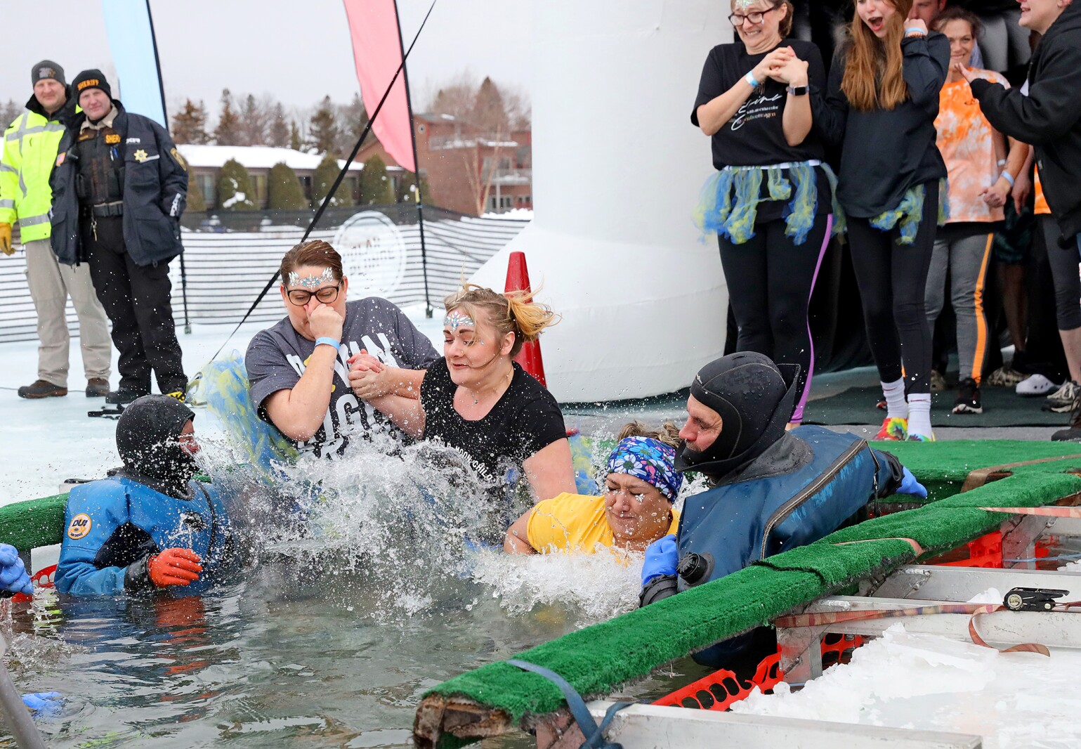 People jump into the water during the Polar Plunge event on Pelican Lake.