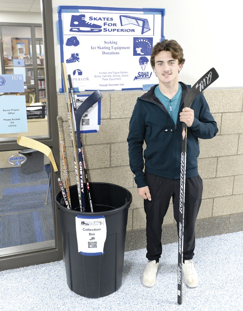 Jed Carlson / jcarlson@superiortelegram.com Senior Trevor Dalbec stands with a few of the items collected at the drop off area in Superior High School on Monday, Dec. 3. Dalbec is collecting hockey equipment at multiple sites in Superior until Dec. 21.