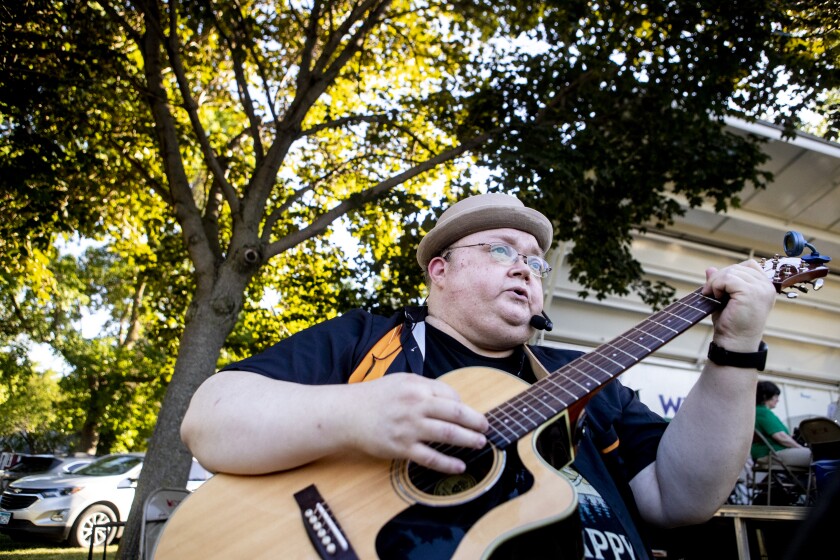 Jay Ellingson of the band, Acoustic Vibe, strums his guitar while performing at Rice Park on Wednesday, June 22, 2022.