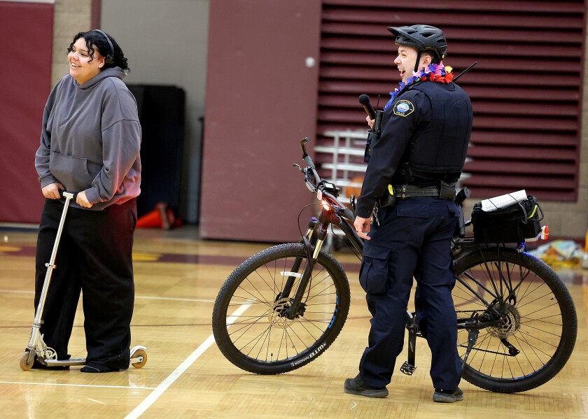 Student laughs with police officer during skit.