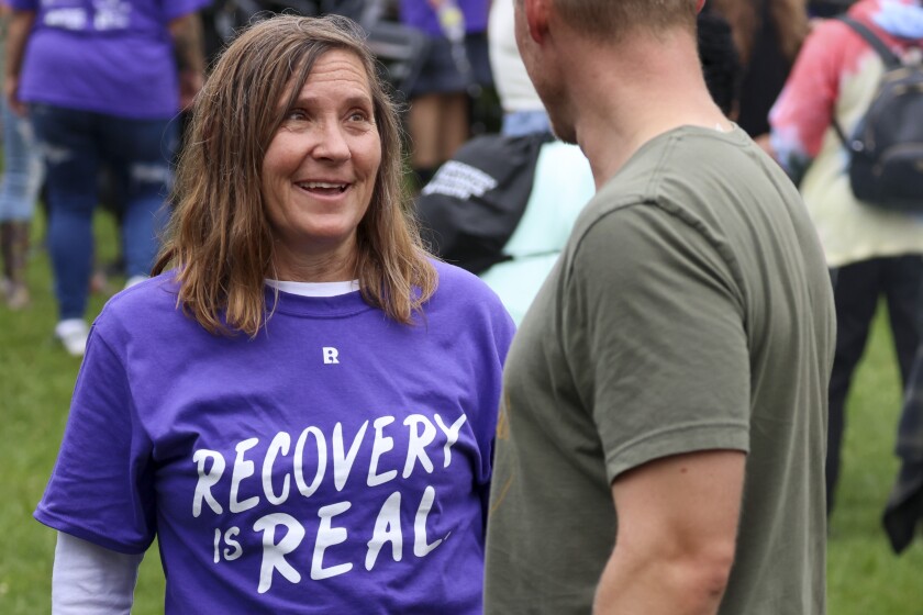 People in purple shirts celebrate recovery in outdoor park