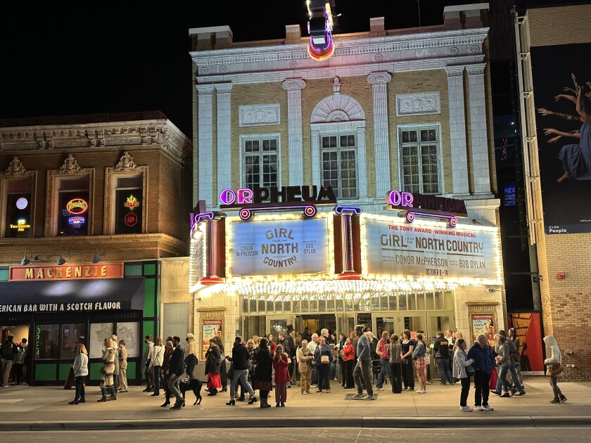 Orpheum Theatre marquee is seen at night with signage advertising "Girl from the North Country." People crowd on sidewalk.