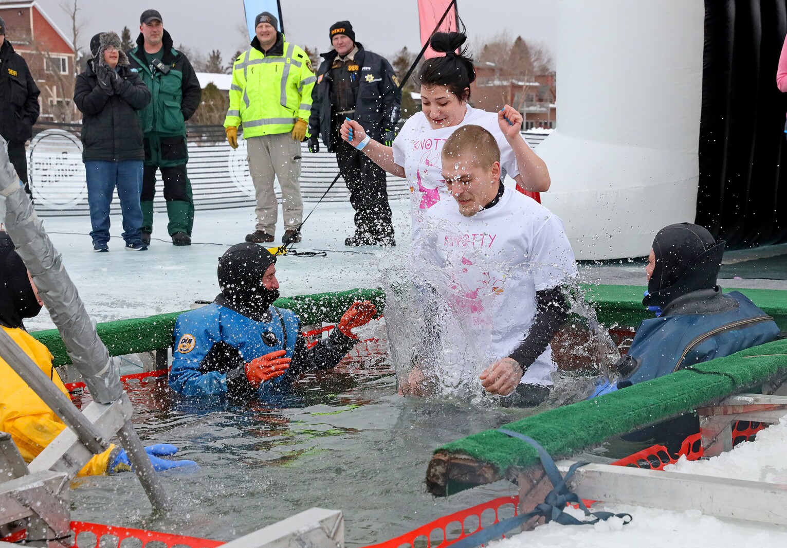 People jump into the water during the Polar Plunge event on Pelican Lake.