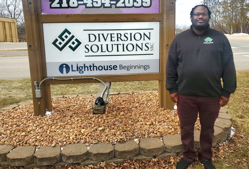 Man stands by "Diversion Solutions" sign