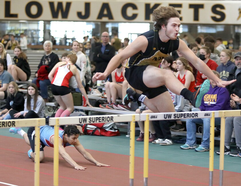 Northwestern’s CJ Thompson clears a hurdle for a second place finish in the 55 meter hurdles as Superior’s Isaiah Essien falls