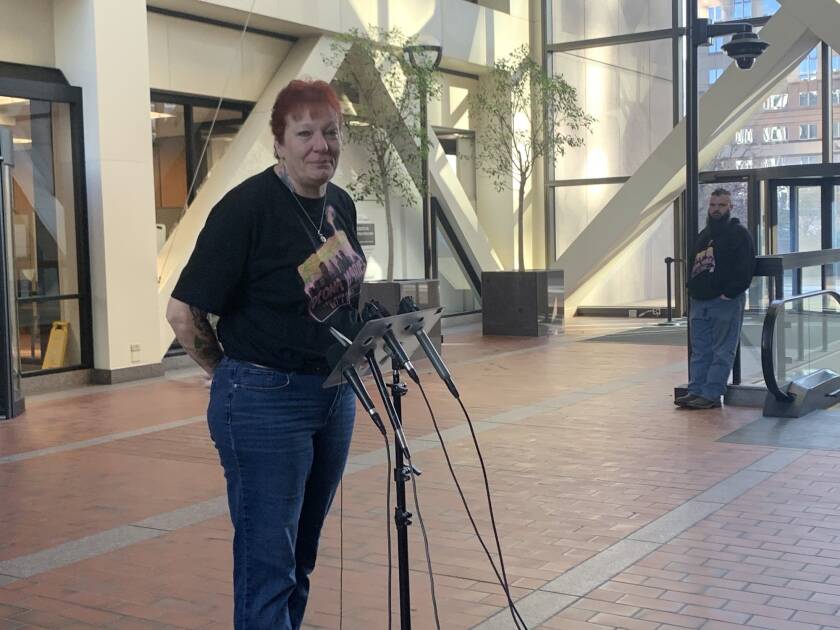431a93-20221123-a-woman-stands-in-front-of-microphones-2000.jpg