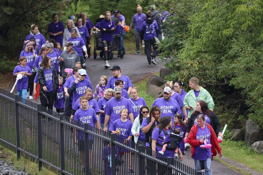 People in purple shirts celebrate recovery in outdoor park