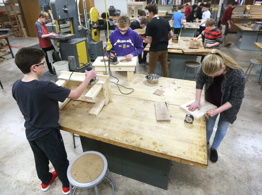 t3.16.17 Bob King -- 031917.N.DNT.SEVENc3 -- 8th graders in Ordean East's industrial tech class, an elective, work with focus on their projects that include dog bowl tables (left), cutting boards and phone speaker holders. Bob King / rking@duluthnews.com