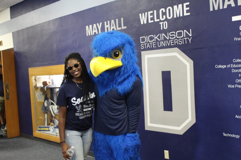 A DSU student poses for a photo with Blue Hawks mascot "Buster" before the convocation ceremony on Monday in Stickney Auditorium. (Press Photo by Sydney Mook)