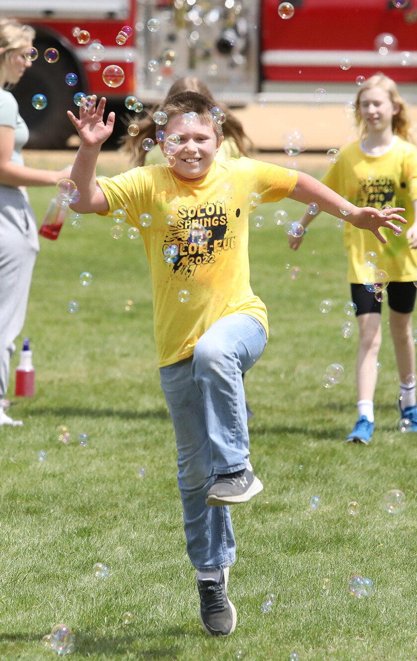 Conner Benson smiles as he jumps through bubbles