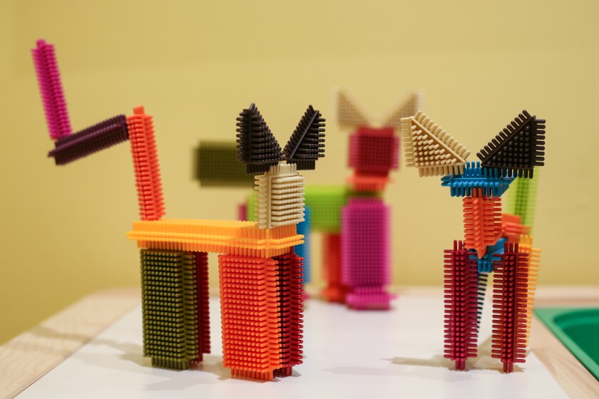 Making cat-themed sculptures with colorful building blocks is one of the hands-on activities at The Rourke's Gallery Cats exhibition in the Children's Gallery. There are three building block cat sculptures on a table.