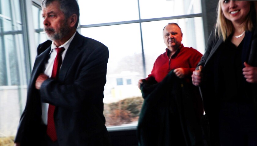 Kent Pfaff walks out of the federal courthouse in Bismarck, ND, led by his legal team.