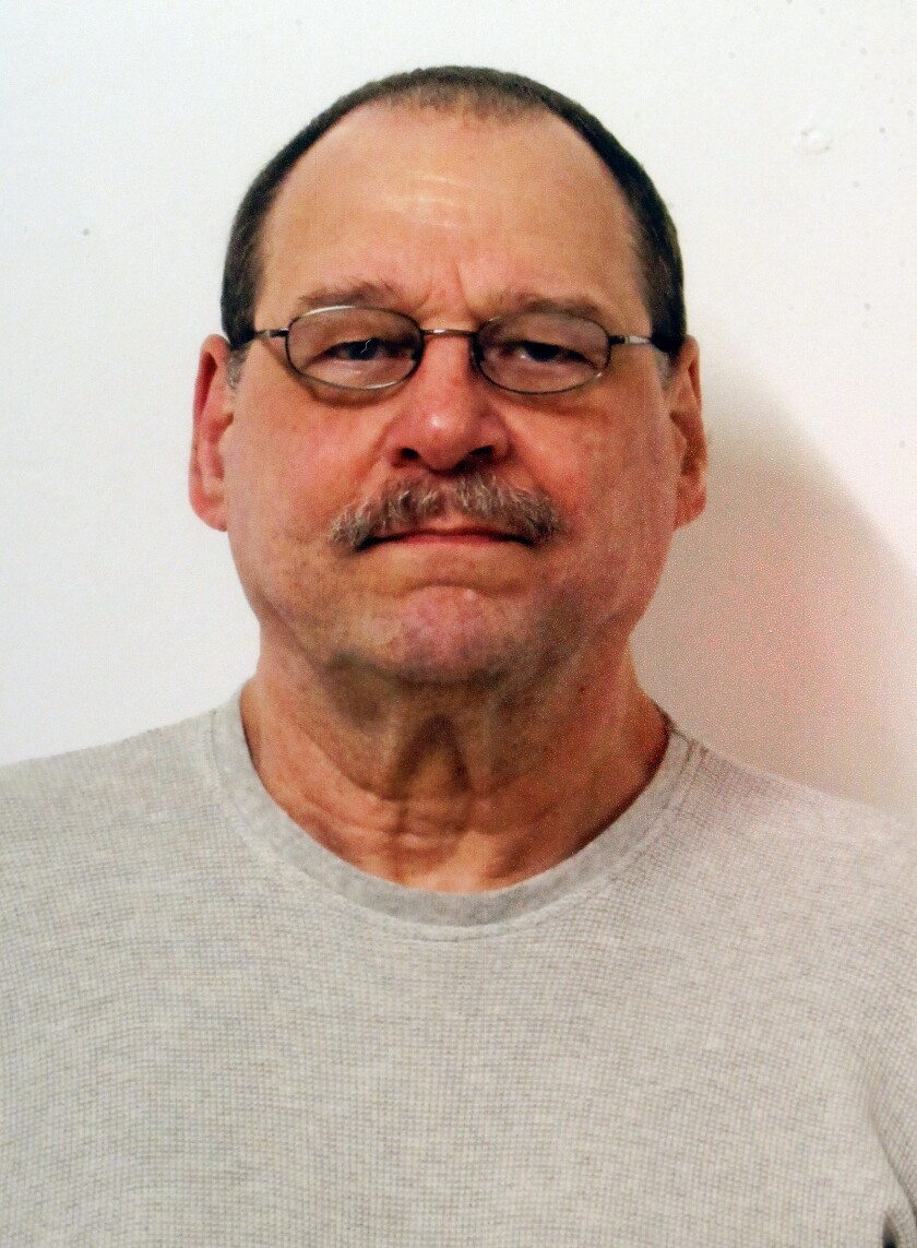 Portrait photo of a light skinned man with round wire glasses.
