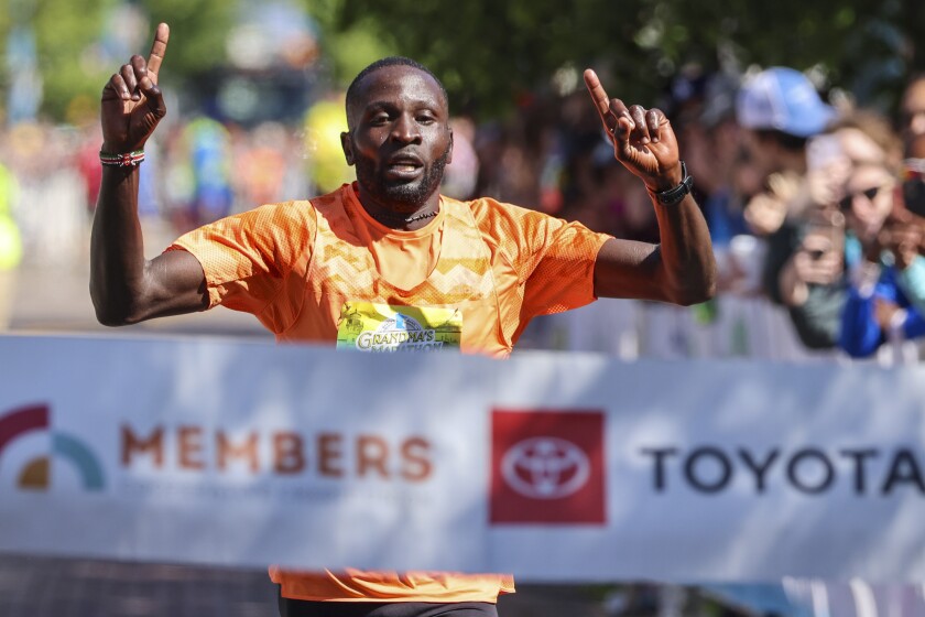 Athletes running and celebrating at the finish line area of Grandma's Marathon