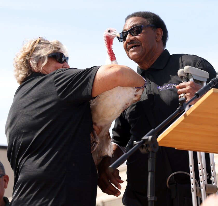 Susanne Murphy, president of the King Turkey Day Board of Directors, presents Paycheck to featured speaker and former Minnesota Vikings player Walter Eugene "Chuck" Foreman for a kiss of good luck prior to the first leg of the Great Gobbler Gallop on Saturday, Sept. 17, 2022, in Worthington.