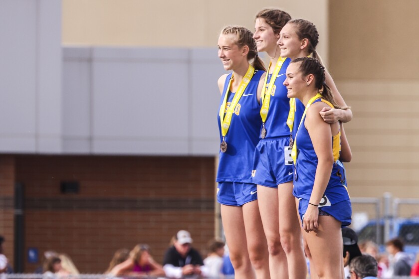 Athletes compete in track and field events at outdoor stadium