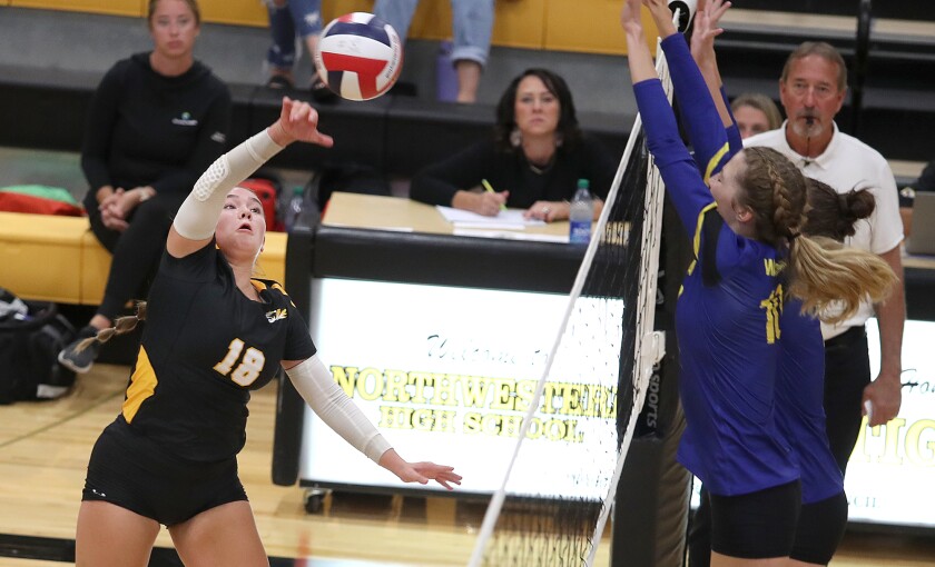 Northwestern’s Kayla Paulsen (18) hits the ball past the Rice Lake block