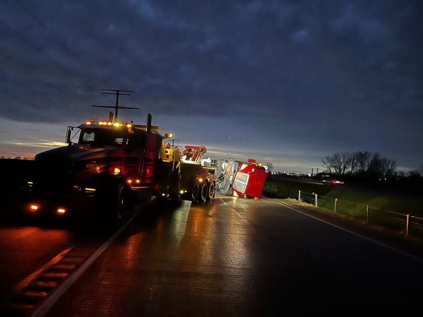 A tow truck works to right an overturned semi-truck on Thursday night, May 12, 2022, on eastbound Interstate 94 near Alexandria, Minnesota.