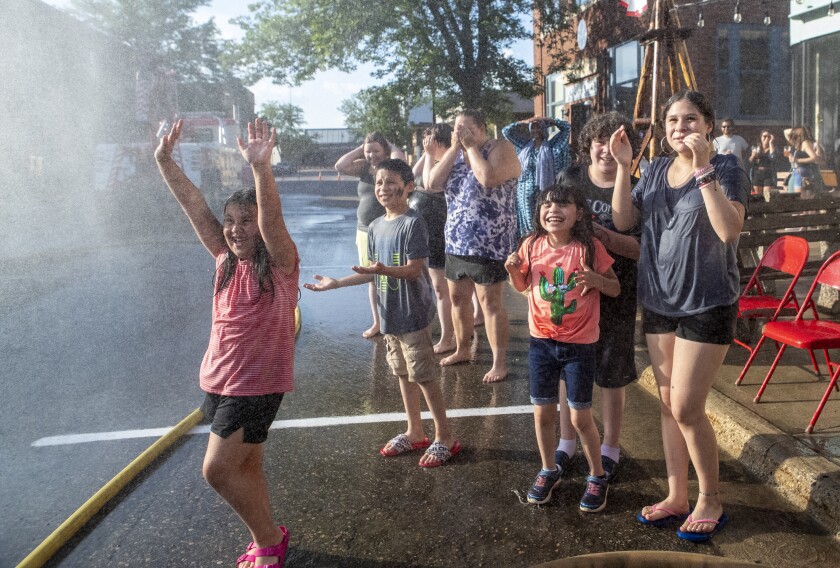 Children beat the 102-degree afternoon heat with water spraying from the hoses of the fireman's challenge in downtown Willmar during Willmar Fest on Thursday, June 23, 2022.
