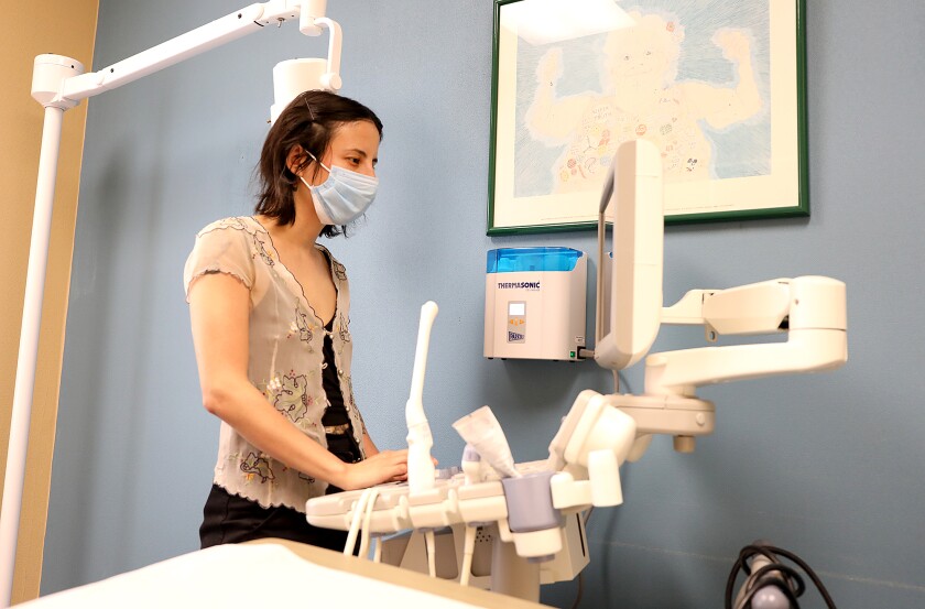 Paulina Briggs, the lab supervisor at WE Health Clinic, checks a machine in the exam room