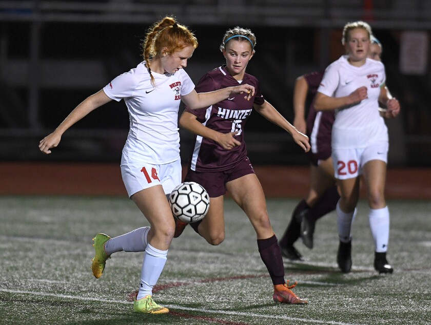 Duluth East’s Taitum Snustad (14) and Duluth Denfeld’s Alyssa Doyle (15) jockey for the ball