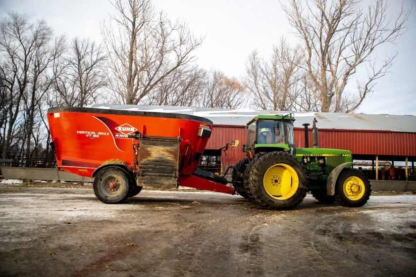 James Orsten moves equipment across the farm to prepare for feeding cattle on Tuesday, Jan. 18, 2022