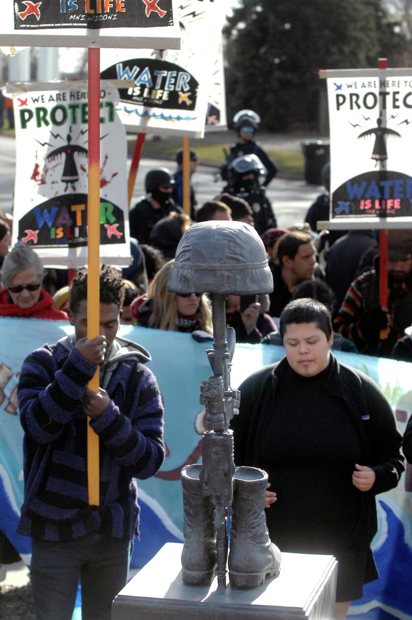 About 100 Dakota Access Pipeline protesters pray Wednesday, Nov. 16, 2016, at The Memorial to The Fallen in Global War on Terrorism after marching from the Bank of North Dakota to the North Dakota National Guard Fraine Barracks in Bismarck. MIKE MCCLEARY / BISMARCK TRIBUNE