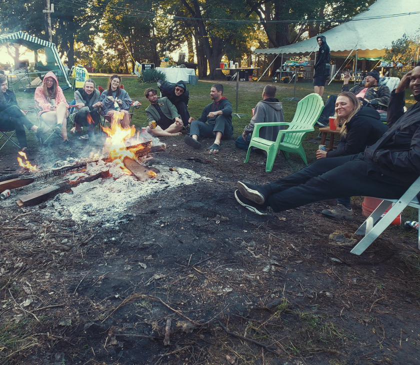 Festival goers sitting around a campfire at Prairie Fyre