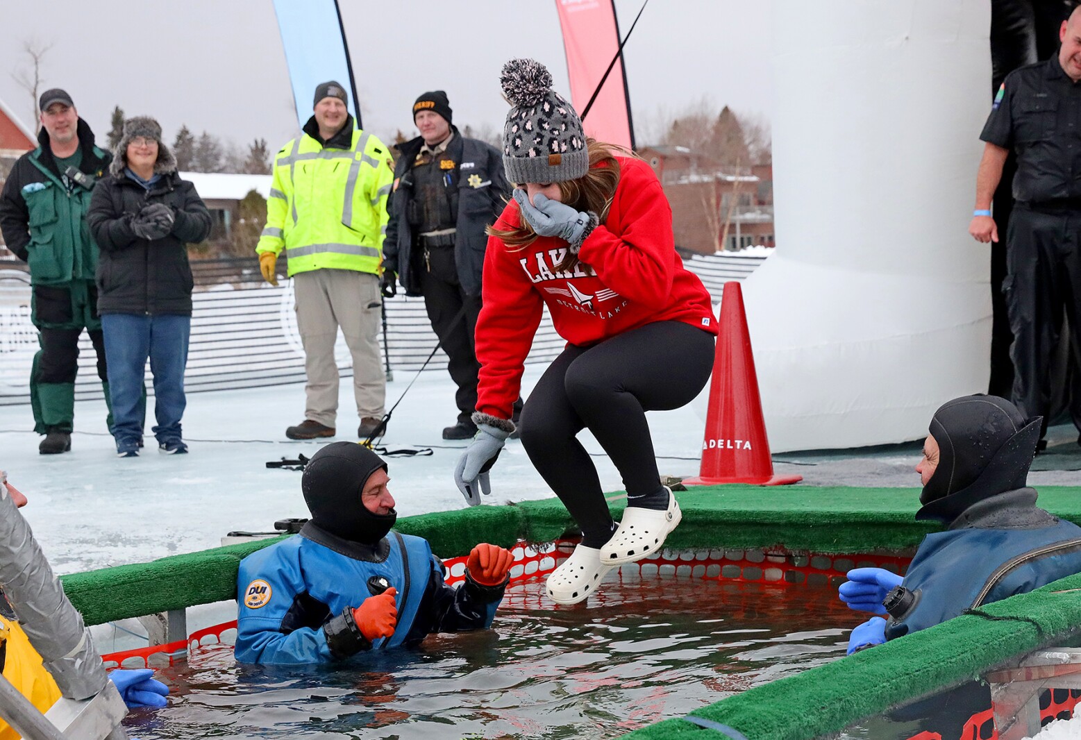 People jump into the water during the Polar Plunge event on Pelican Lake.