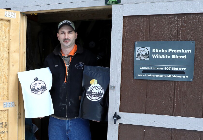 Jim Klinkner, the creator of Klinks Premium Wildlife Blend, holds two bags of product in his Dairyland shed