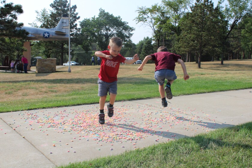 Leonardo and Nicholas Leany were all-too-happy to help crush a pile of fruity cereal into colorful powdery dust at this year's Chalk Walk in Dickinson Friday. Iain Woessner / The Dickinson Press