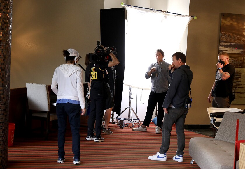 “Merry Kiss Cam” director Lisa France, left, talks with her crew as they before to set up a secondary shot