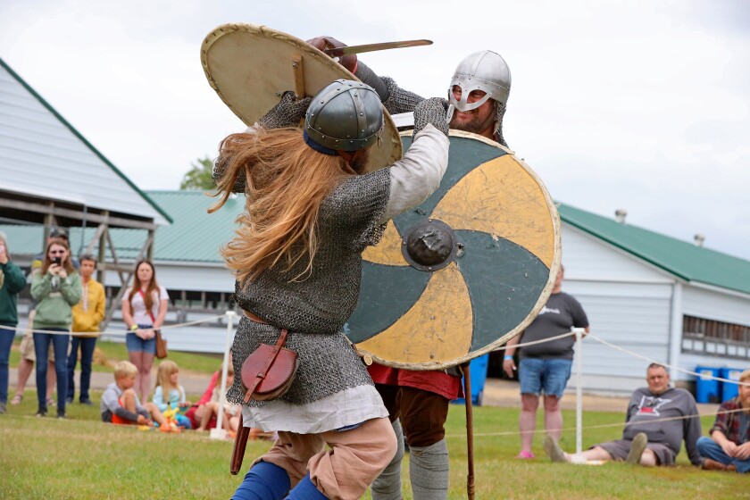 Viking warriors use weapons armor and shields to demonstrate fighting techniques.