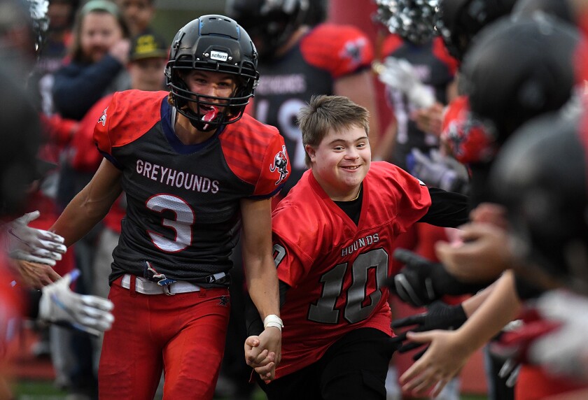 Duluth East’s Zach Ronn (3) and Gavin Reller (10) laugh together as they run down the chute, slapping hands after Reller was announced before the Greyhounds game