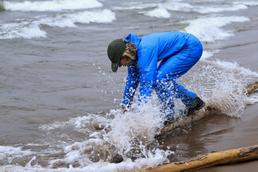 artist on Lake Superior beach unsettled cloudy rainy day