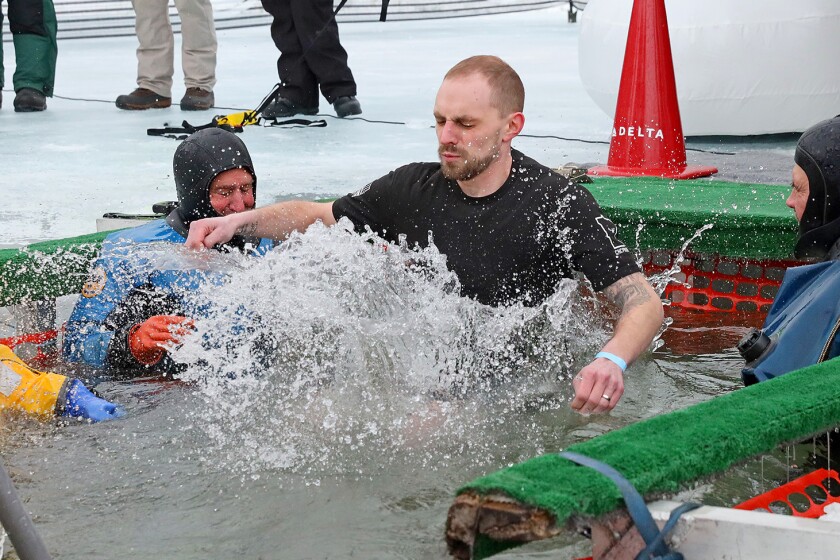 People jump into the water during the Polar Plunge event on Pelican Lake.