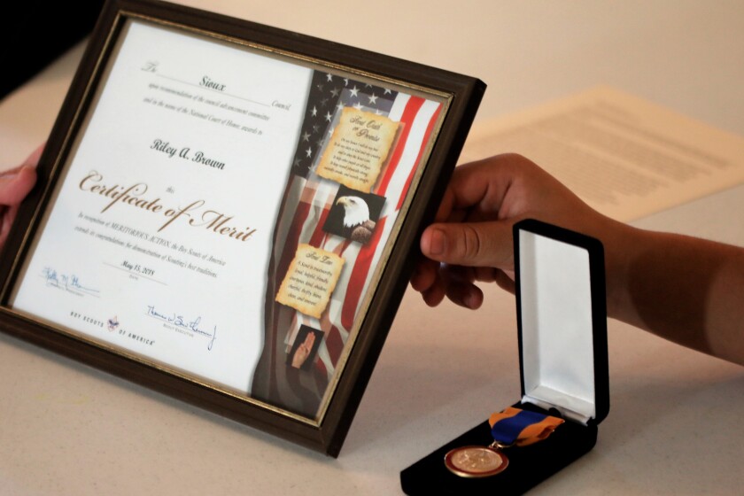 From left to right: Riley Brown's Certificate of Meritorious Action is propped up next to his medal. (Sam Fosness / Republic)
