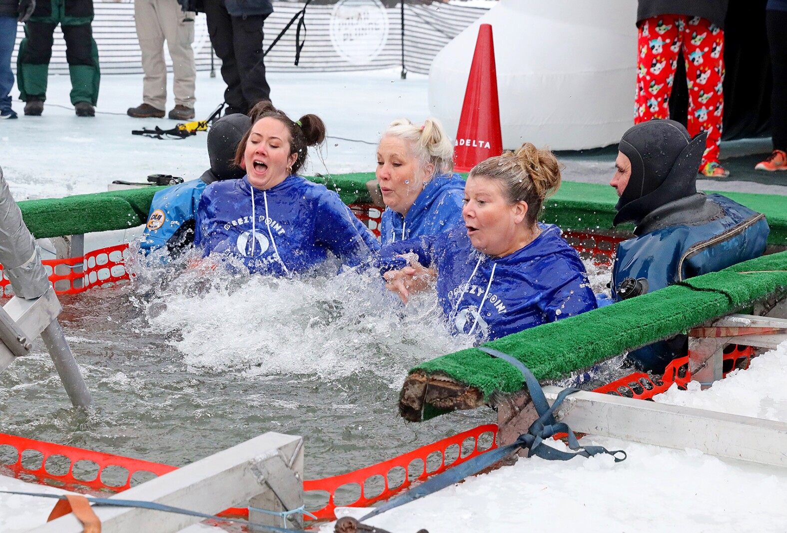 People jump into the water during the Polar Plunge event on Pelican Lake.