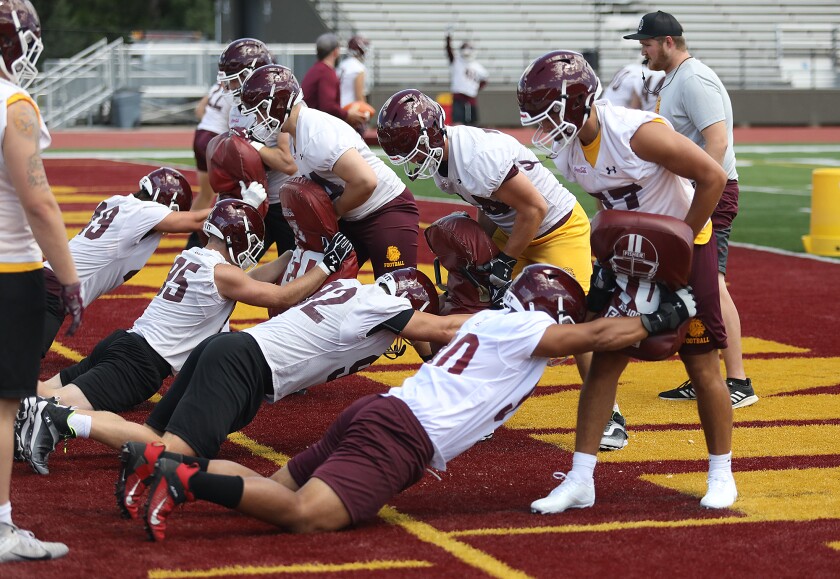 The Minnesota Duluth defensive line unit hits blocking pads