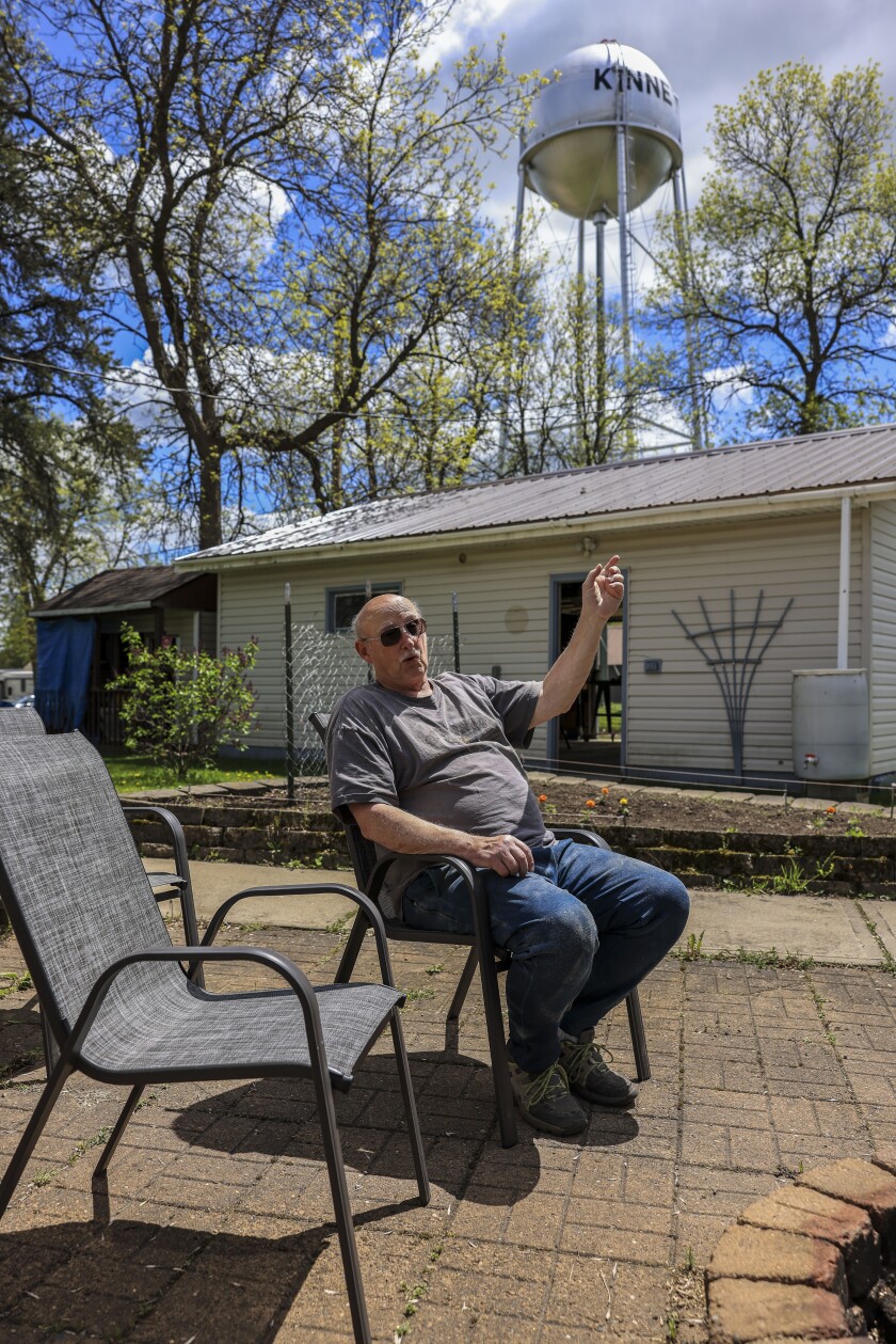man sitting in chair outside in small mining town