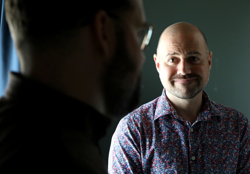 Man listens to other man speak.