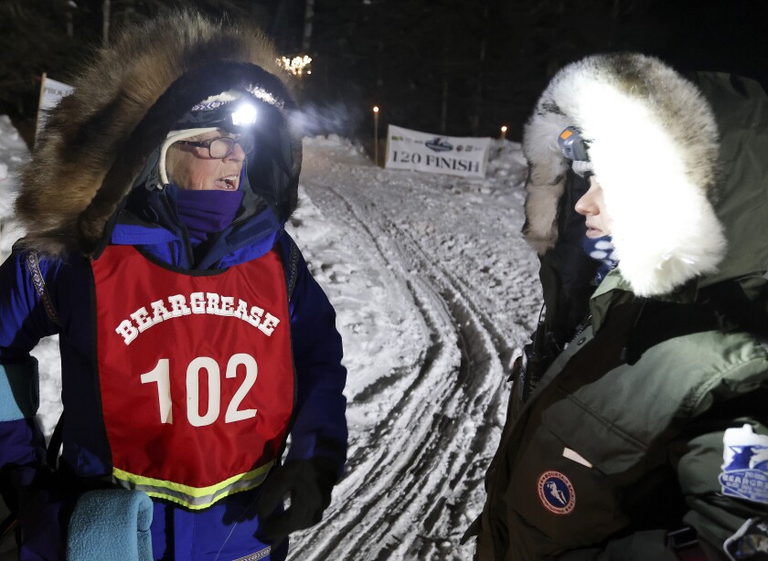 Musher talks to vet.