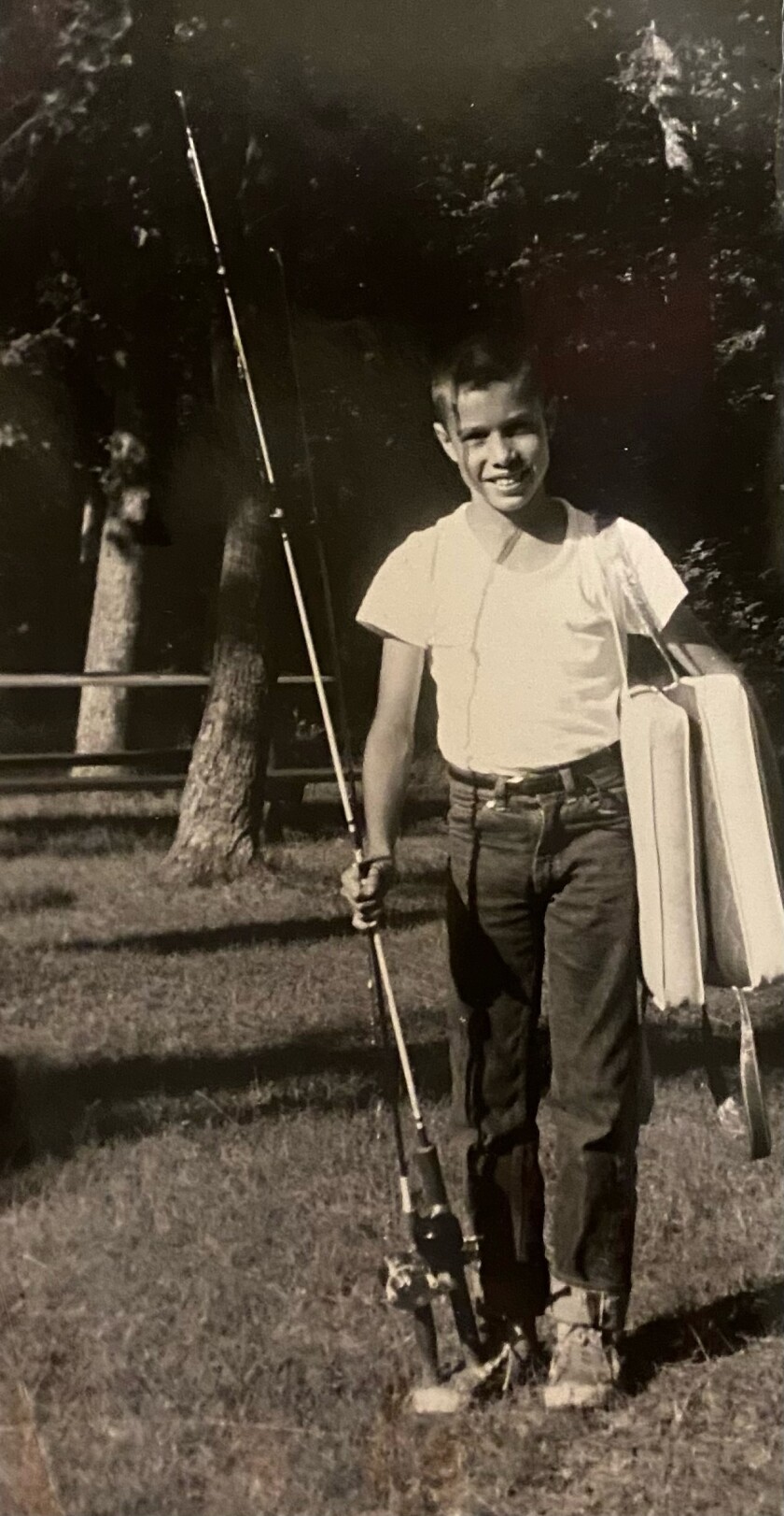 Young and smiling Doug Hamilton holds a fishing rod