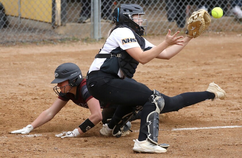Northwestern catcher Abby Wennersten (20) fields a throw as Spooner’s Lily Hotchkiss (13) beats the ball to home plate