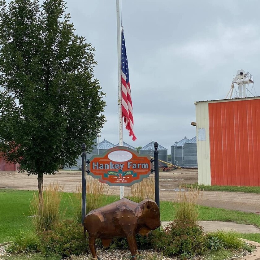 A flag on a still day sticks out above a sign that says Hankey Farm.