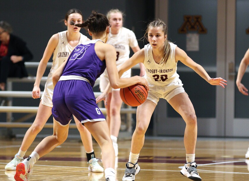 A girls basketball player defends another player