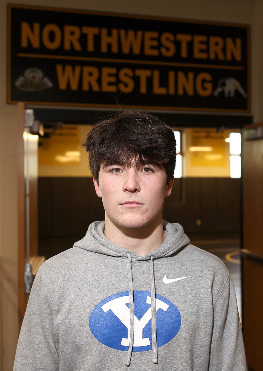 Wrestler stands outside of wrestling room.