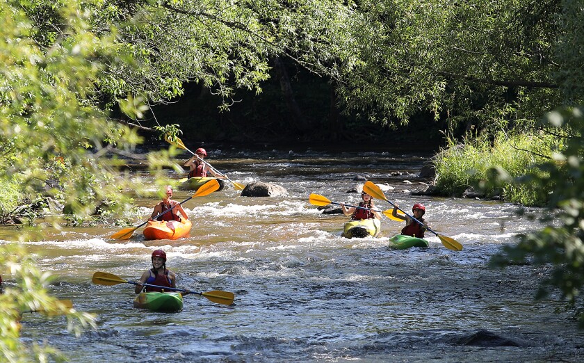 A group of kayakers make their way down the Brule River