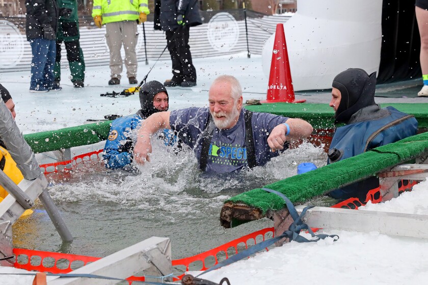 People jump into the water during the Polar Plunge event on Pelican Lake.