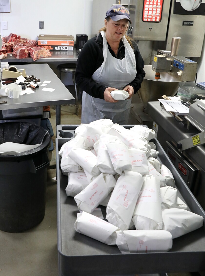 Julie Litchke talks about the butchering process as she labels packages at Litchke Farms